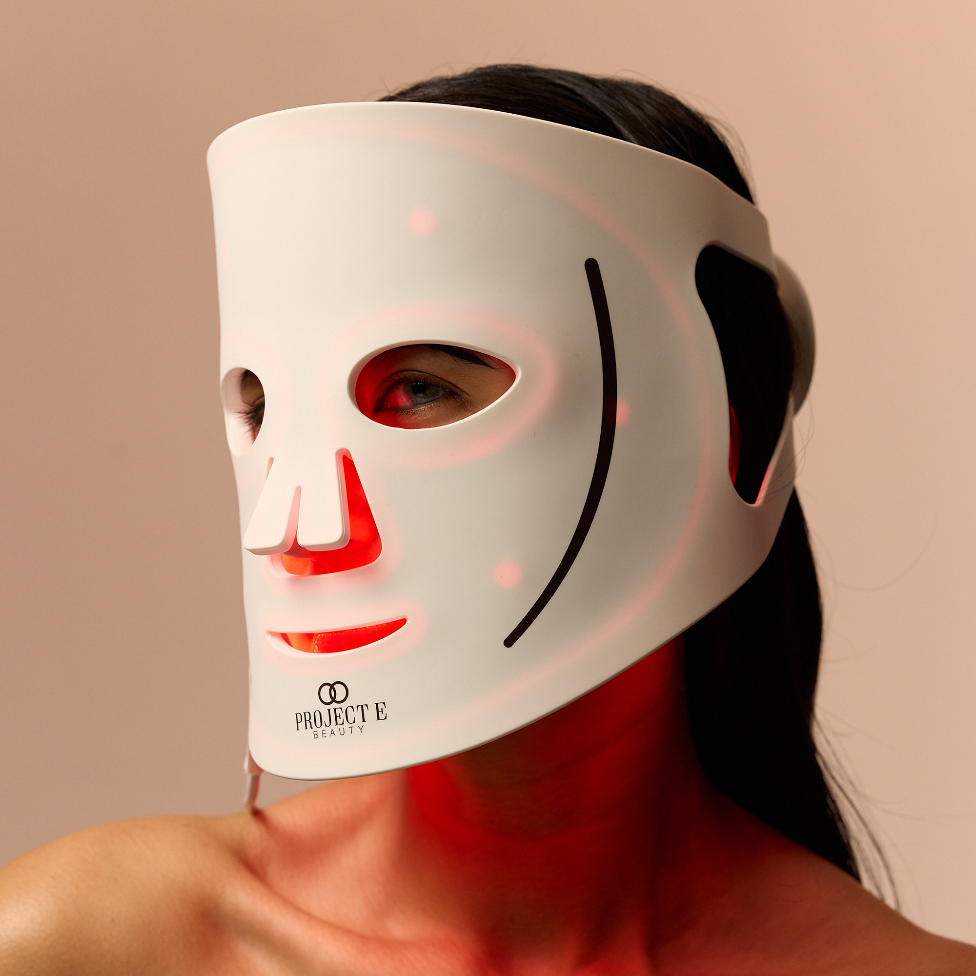 Woman using red light mask for anti-aging benefits