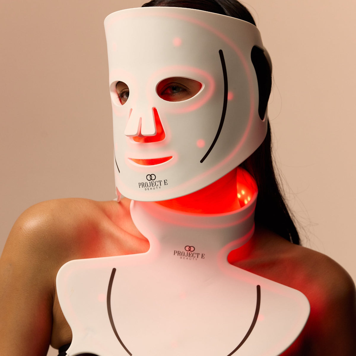 A close-up of a model wearing a Project E Beauty LED face and neck therapy mask.