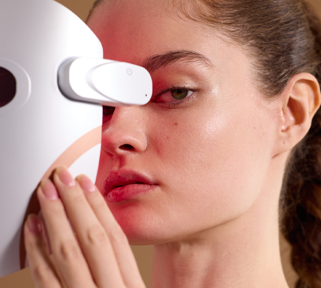 Woman using hands-free LED mask with red light technology