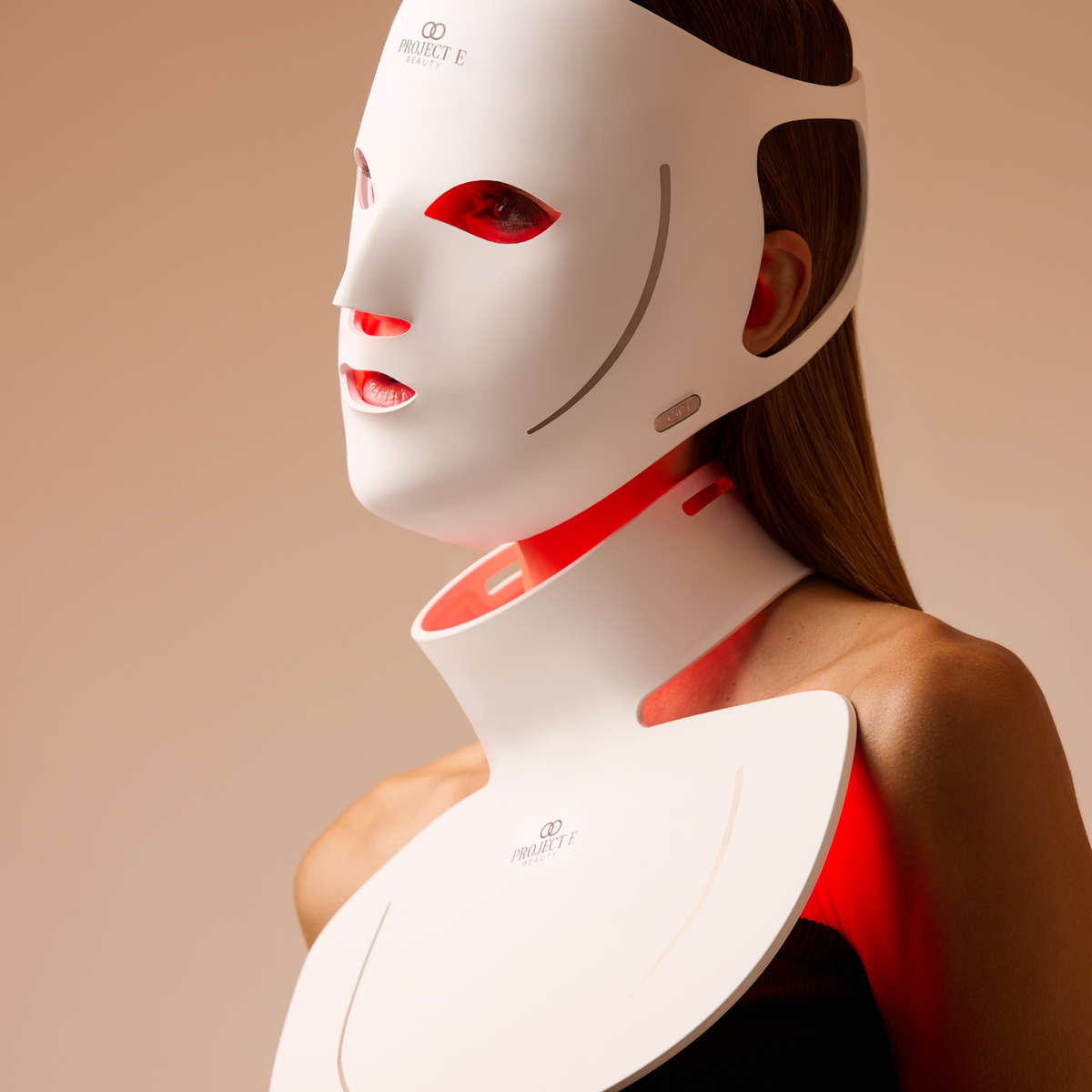 Vue latérale d’une femme portant le masque visage et cou LumaLux Face+ V2 allumé
